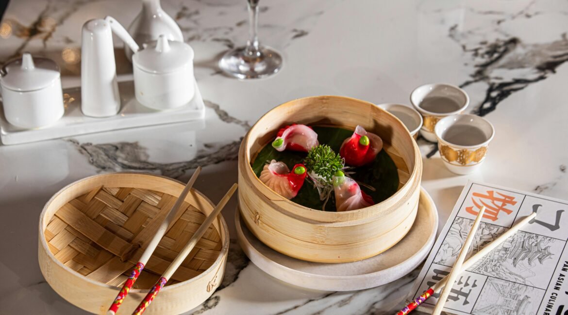 "Pratos de dim sum em recipientes de bambu, com pauzinhos ao lado, representando uma abordagem de dietoterapia chinesa saudável."